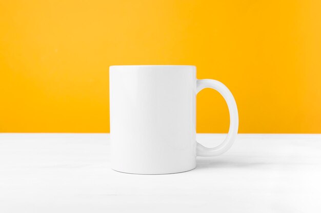 Tazza in ceramica bianca con vista frontale dello spazio di copia vuoto Cup mockup per la pubblicità e il logo su un tavolo di legno