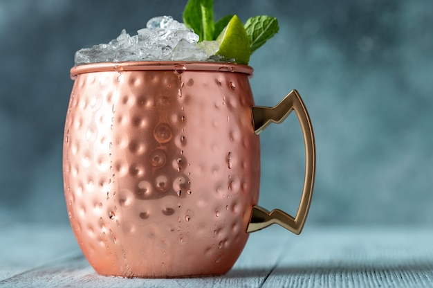 Tazza in rame di cocktail Moscow Mule guarnita con menta e lime