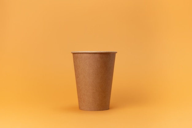 Tazza monouso in cartone per caffè isolata su fondo beige