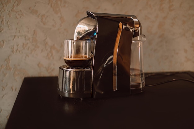 Tazza professionale moderna della macchina per caffè espresso sul tavolo della cucina facendo colazione al mattino