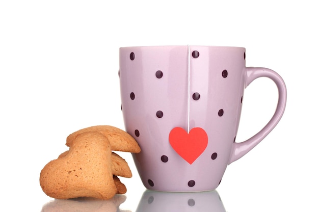 Tazza rosa con bustina di tè e biscotti a forma di cuore isolati su bianco