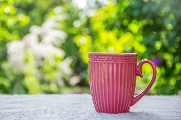 Tazza rosa con caffè nel giardino