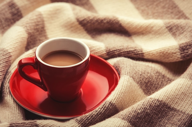 Tazza rossa di caffè e sciarpa vintage