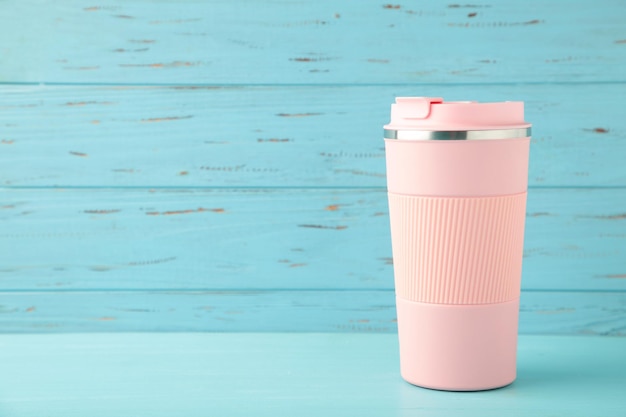 Tazza termica rosa o tazza termica per tè o caffè su sfondo blu Bevanda calda