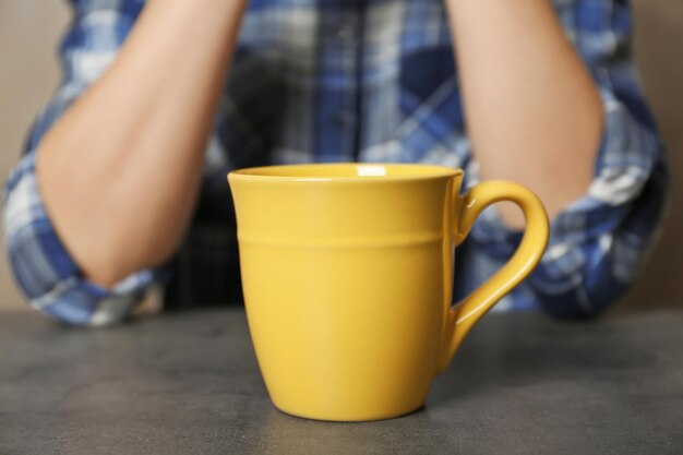 Tazza vuota e donna sullo sfondo