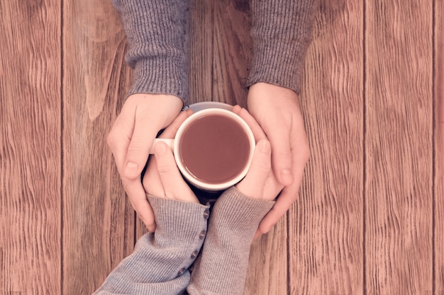 Tazze con un caffè nelle mani di uomini e donne.