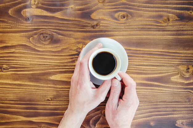 Tazze con un caffè nelle mani di uomini e donne.