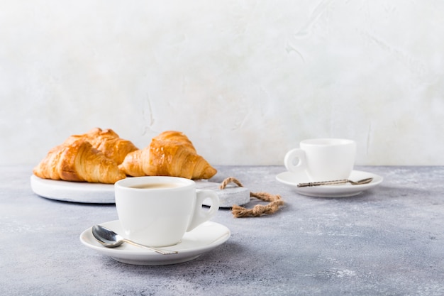 Tazze da caffè bianche e cornetti