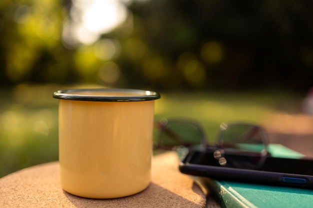 Tazze da caffè in giardino e sole mattutino.