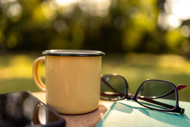 Tazze da caffè in giardino e sole mattutino.