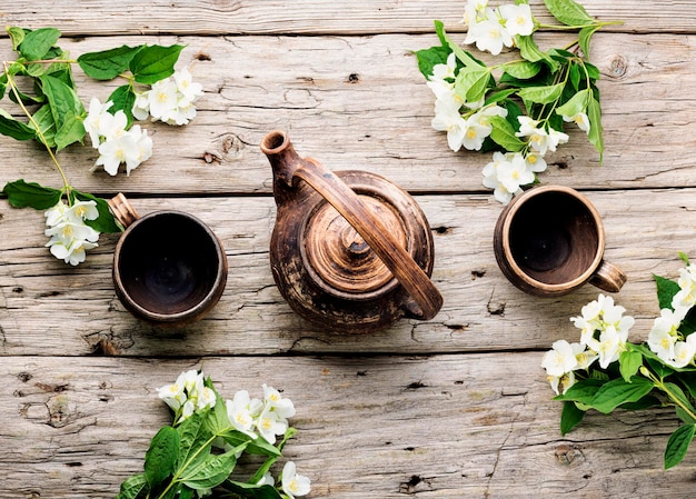 Tazze da tè e teiera di argilla. Tisana di fiori di gelsomino. Medicina di erbe.