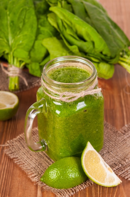 Tazze di barattolo di vetro riempite con spinaci verdi e frullato di cavolo verde