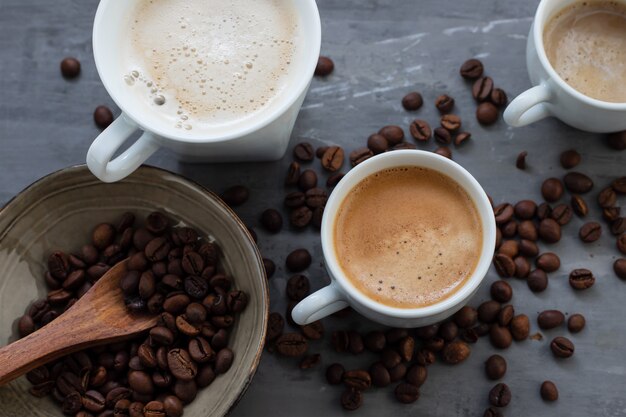 Tazze di caffè con latte e cereali su fondo in ceramica