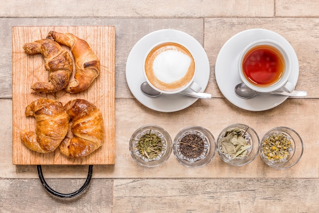 tazze di caffè e tè e colazione sulla tavola di legno