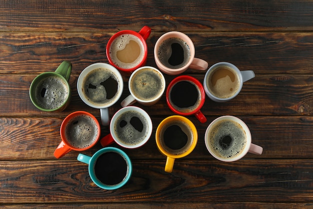 Tazze di caffè multicolori su fondo di legno