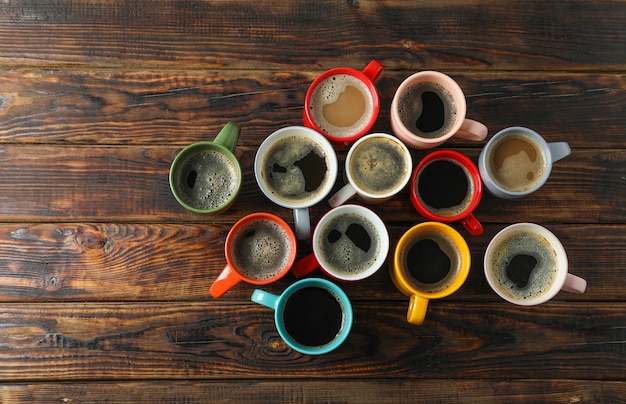 Tazze di caffè multicolori su fondo di legno