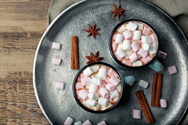 Tazze di cioccolata calda con marshmallow sul vassoio, primo piano