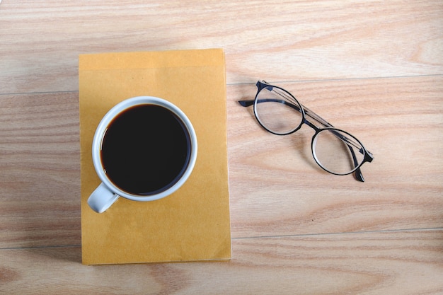 Tazzine da caffè, libri, bicchieri su tavole di legno