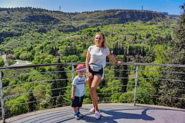 Tbilisi GeorgiaAprile 28 2019 una giovane ragazza con un bambino sullo sfondo di una vista del verde dalle mura della fortezza di Narikala