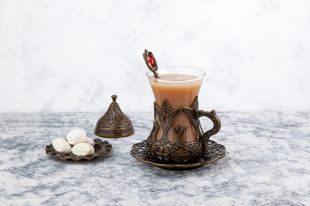 Tè Adrak o Masala chai Tè indiano allo zenzero con latte e spezie su sfondo grigio