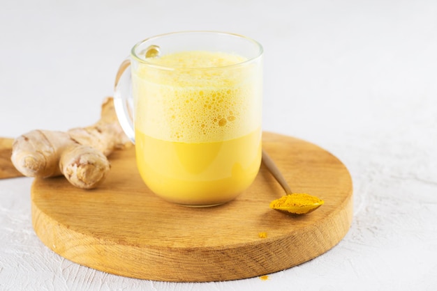 Tè al latte alla curcuma con latte di mandorla zenzero curcuma e cannella in una tazza senza zucchero e lattosio