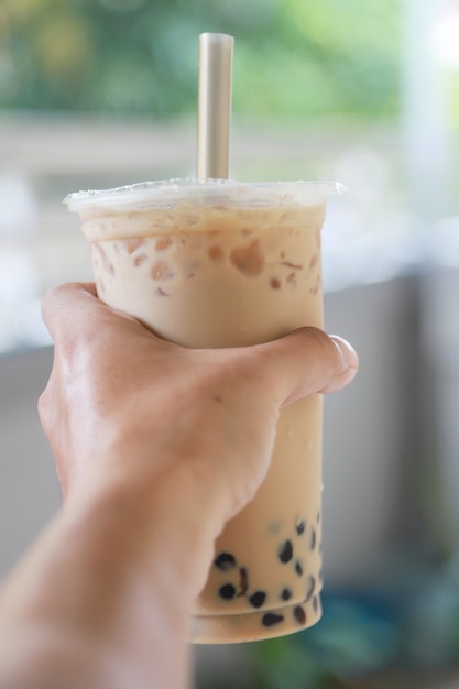 Tè al latte freddo con bubble boba bevanda fresca e dolce in stile Taiwan nella mano mostra bere, cibo e bevande concept