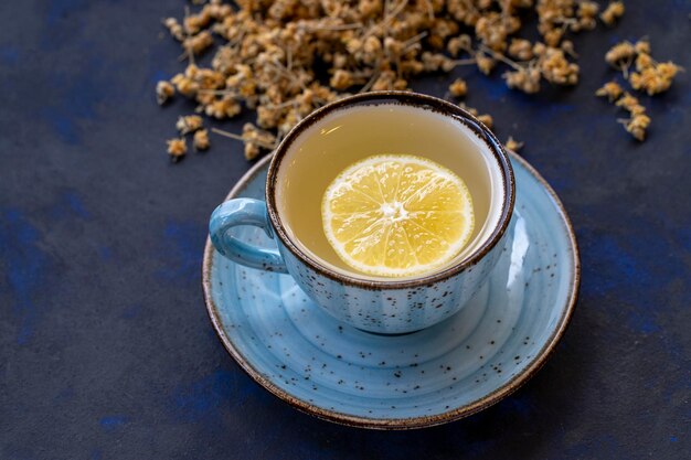 Tè al tiglio in una tazza su sfondo nero e blu