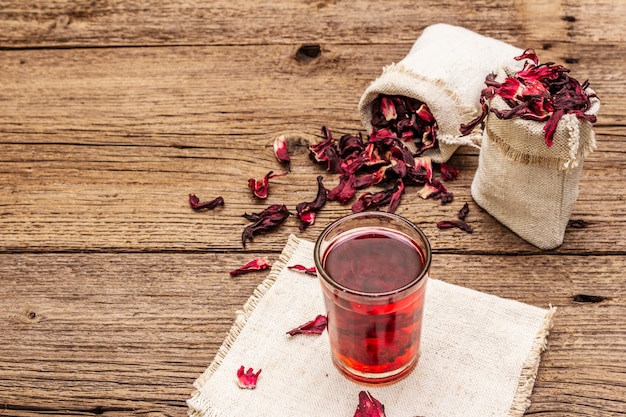 Tè all'ibisco caldo. Petali secchi, sacchi di lino. Cibo sano e concetto di cura di sé.