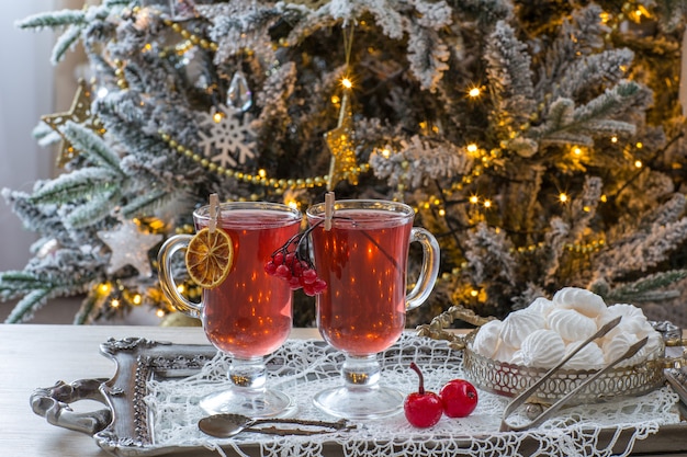 tè alla frutta in tazze e meringhe con albero di Natale