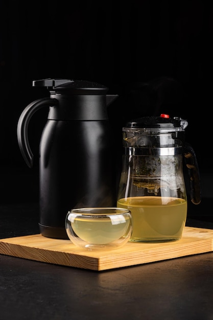 Tè alla frutta in una teiera trasparente e bicchiere e thermos