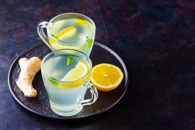 Tè allo zenzero con limone e menta in tazze di vetro