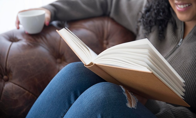 Tè bevente della ragazza che legge un libro