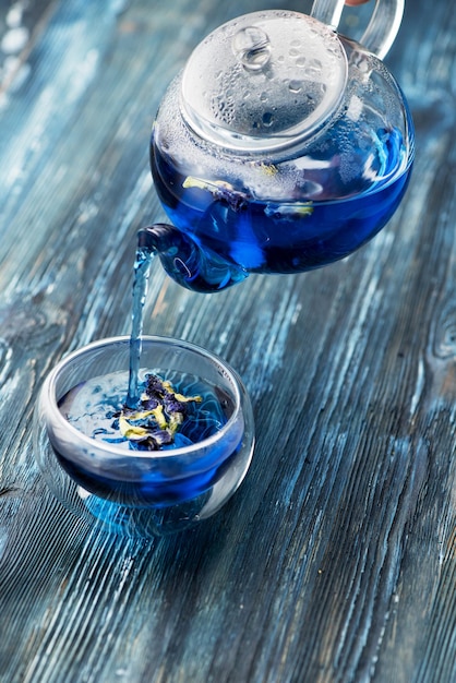Tè blu biologico Anchan in una teiera di vetro e una tazza