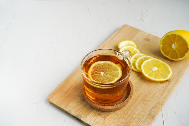 Tè caldo al limone su una tavola di legno. Una bevanda calda per raffreddori.