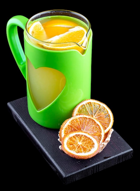 Tè caldo con arance e limone su sfondo nero