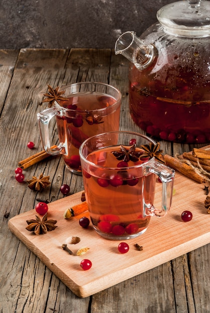 Tè caldo della frutta calda della bevanda di autunno con l'anice di cannella del mirtillo rosso su una vecchia tavola di legno rustica