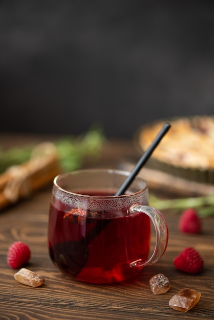 Tè caldo di ibisco con cannella e zucchero su un tavolo di legno