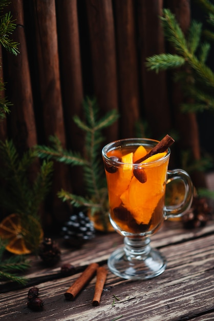 Tè caldo e frutta arancio sulla tavola di legno