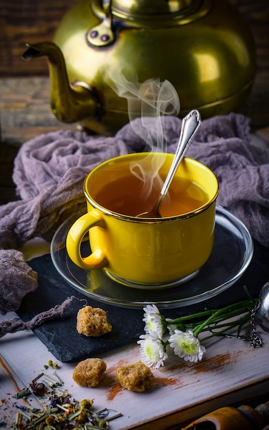 Tè caldo in una tazza su un vecchio tavolo.