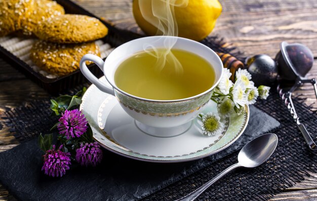 Tè caldo in una tazza su un vecchio tavolo.