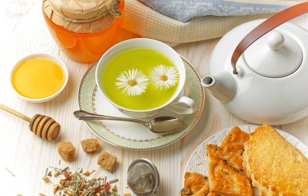 Tè caldo in una tazza su uno sfondo bianco.