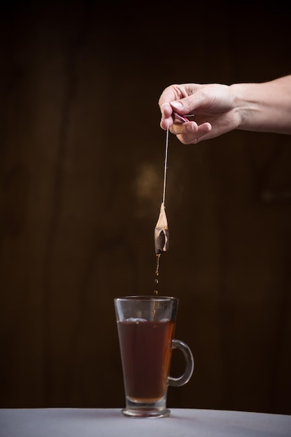 Tè che gocciola in tazza con il concetto di colazione con acqua calda