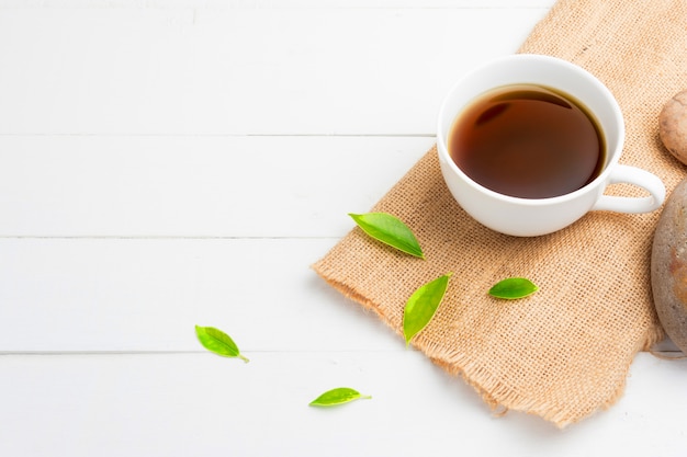 Tè con bicchiere di tè su legno bianco