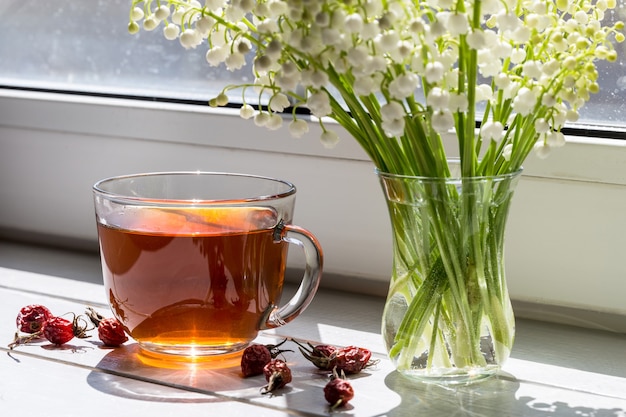 Tè con rosa canina e bouquet di gigli primaverili