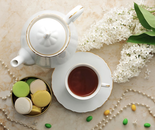 Tè del mattino con biscotti, macarons e un ramo di lillà