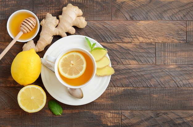 Tè di radice di zenzero con limone e miele sul tavolo di legno. Vista dall&#39;alto, distesi, copia spazio.