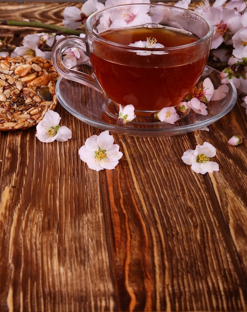 Tè e un ramo di fiori di ciliegio su un legno