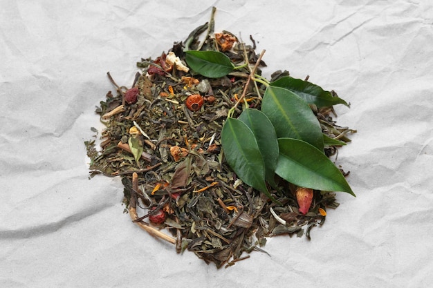 Tè essiccato con foglie su sfondo di carta