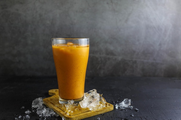 Tè freddo al latte in un bicchiere con ghiaccioTè freddo al latte in un bicchiere con ghiaccio