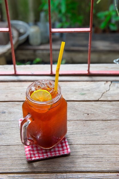 Tè freddo al limone e lime sul tavolo vitage in una brocca